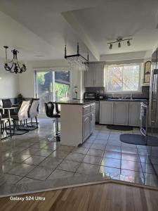 a kitchen and living room with a table and chairs at Appartement, Jacuzzi et terasse in Longueuil