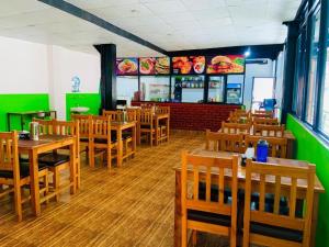 a restaurant with wooden tables and chairs and green walls at Hotel Good one in Pokhara