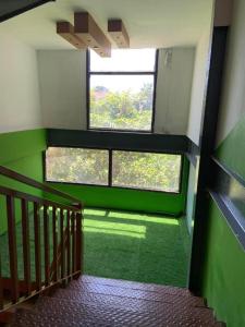 uma sala com paredes verdes e duas janelas em Hotel Good one em Pokhara