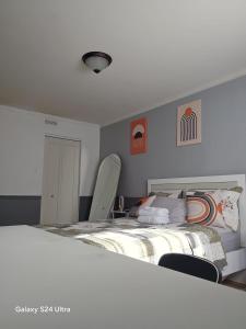 a bedroom with a large bed and two chairs at Appartement, Jacuzzi et terasse in Longueuil