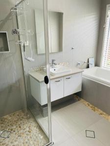 a bathroom with a shower and a sink at Stones Throw at Sapphire in Coffs Harbour
