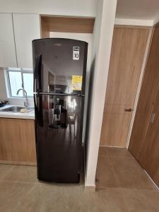 a black refrigerator in the corner of a kitchen at Cartagena zona norte playa uso exclusivo in Cartagena de Indias