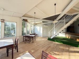 a room with tables and chairs and a staircase at 玄関開けたらスキー場!400平米の贅沢空間で大型犬もOKシアタールーム完備 Skiin 400m2 Luxury Lodge Large Dogs OK Big Theater Room in Yonezawa