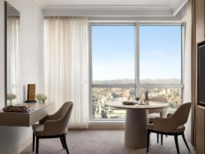 麦加Movenpick Hotel & Residences Hajar Tower Makkah的带桌椅和大窗户的客厅
