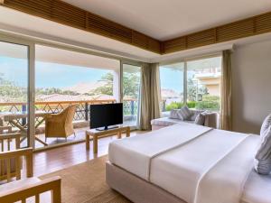 a bedroom with a large bed and a balcony at Mövenpick Resort Aswan in Aswan +236 photos