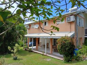 a house with a white awning and a yard at Chez Fab & Ketty in Le Moule