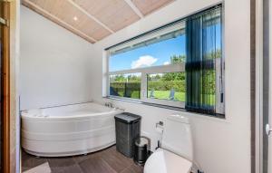 a bathroom with a tub and a window at Stunning Home In Tarm With Sauna in Højsand +29 photos