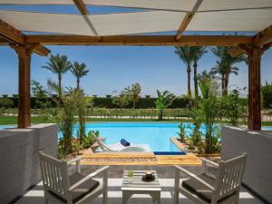 a patio with two chairs and a swimming pool at Movenpick Waterpark Resort & Spa Soma Bay in Hurghada