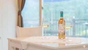eine Flasche Wein und zwei Gläser auf einem Tisch in der Unterkunft Gapyeong Rialto Pension in Gapyeong