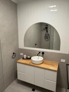 a bathroom with a sink and a mirror at The Townhouse in Renmark