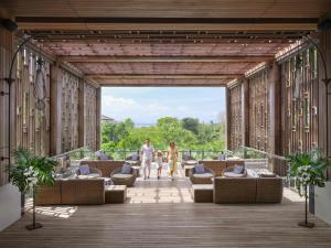 eine Darstellung eines Decks mit Menschen, die durch ein Gebäude gehen in der Unterkunft Mövenpick Resort & Spa Jimbaran Bali in Jimbaran