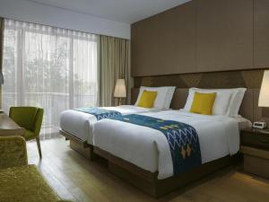 Un pat sau paturi într-o cameră la Mövenpick Resort & Spa Jimbaran Bali