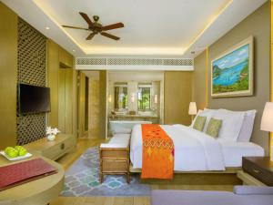 une chambre avec un grand lit blanc et une télévision dans l'établissement Mövenpick Resort & Spa Jimbaran Bali, à Jimbaran 146 autres photos