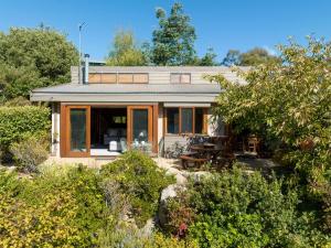 a house with a patio and a table at The Wolery - Lakeside Jindabyne in Jindabyne