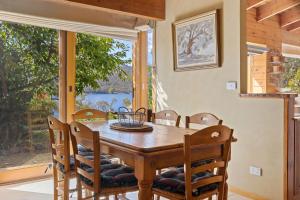 a dining room with a table and chairs and a window at The Wolery - Lakeside Jindabyne in Jindabyne +26 photos