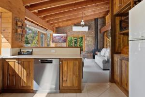 a kitchen with wooden cabinets and a dishwasher at The Wolery - Lakeside Jindabyne in Jindabyne