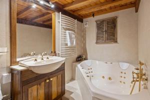 a bathroom with a tub and a sink and a bath tub at The Wolery - Lakeside Jindabyne in Jindabyne