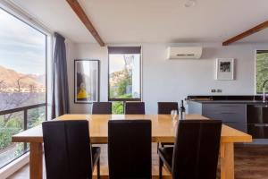 een keuken en eetkamer met een houten tafel en stoelen bij The Twins in Queenstown