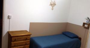 a small bedroom with a blue bed and a dresser at Teros in Caleta Olivia
