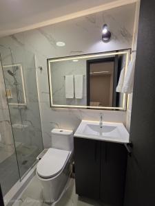 a bathroom with a toilet and a sink and a shower at Moderno apartamento en el centro de Obarrio in Panama City