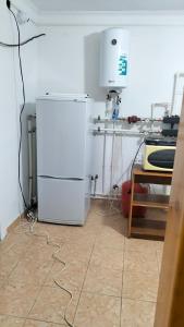 Una cocina con un refrigerador blanco en una habitación. en Хостел Москва, en Aktobe