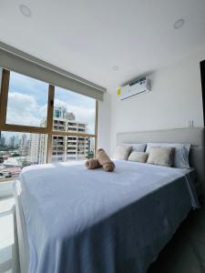 a bedroom with a large bed with a large window at Moderno apartamento en el centro de Obarrio in Panama City