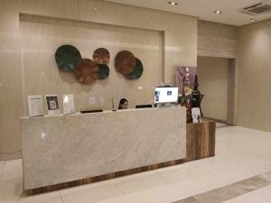 a woman sitting at a counter in a lobby at Condo Unit walking distance to Manila Airport (NAIA Terminal 3) in Manila
