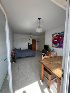 a living room with a bed and a table at Luminoso departamento a tres cuadras del mar in Mar del Plata