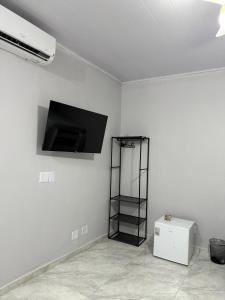 a room with a flat screen tv on a wall at Brisamar Suítes Ilha Grande in Angra dos Reis