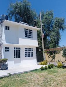 a white house with a yard at Casa Jardín Los Potreros in San Juan Teotihuacán