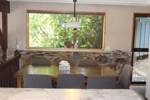 a dining room with a table and chairs and a window at The Cameron Bothy in Queenstown