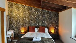 a bedroom with a large bed with two lamps at The Cameron Bothy in Queenstown