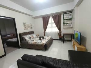 a living room with a couch and a television at Condo Unit walking distance to Manila Airport (NAIA Terminal 3) in Manila +19 photos