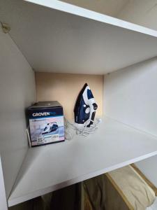 une étagère dans une pièce avec une boîte et une manette de jeu dans l'établissement MACHALI HABITACION PRIVADA PARCKING y WIFI, à Machalí