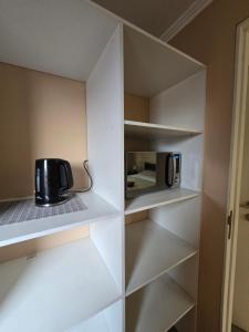 une cuisine avec des étagères blanches et un grille-pain dans l'établissement MACHALI HABITACION PRIVADA PARCKING y WIFI, à Machalí