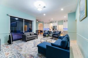 a living room with blue couches and a tv at Large 5BR Home – Pool Table Yard Beaches in Delta