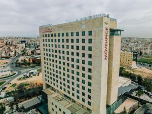 un grand bâtiment avec un panneau sur son côté dans l'établissement Mövenpick Hotel Amman, à Amman