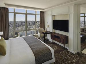 a hotel room with a large bed and a large window at Mövenpick Hotel Amman in Amman