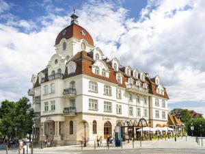 a large white building with a clock tower at Rezydent Hotel Sopot - MGallery Collection in Sopot