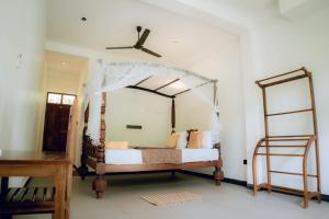 a bedroom with a canopy bed and a ladder at Sea wind in Mirissa