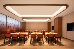 a conference room with tables and chairs and a flat screen tv at Hilton Garden Inn Wuhu Economic Tech Zone in Wuhu