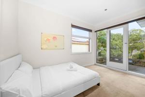 a white bedroom with a white couch and windows at Stylish 4BR Home in the Centro of Glen Waverley in Black Flat