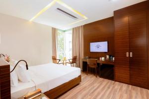 a hotel room with a bed and a desk at Queen Ann Hotel in Ho Chi Minh City +72 photos