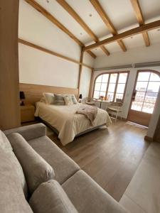 a large bedroom with a bed and a couch at Suites Modernas Coloniales en el Centro Histórico de Cuenca in Cuenca