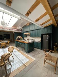a kitchen with green cabinets and a table and chairs at Suites Modernas Coloniales en el Centro Histórico de Cuenca in Cuenca