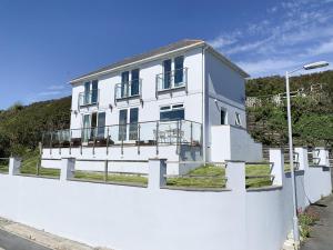 a white house behind a white fence at Looe Island View in Torpoint
