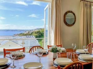 Un comedor con una mesa y un gran ventanal. en Looe Island View, en Torpoint