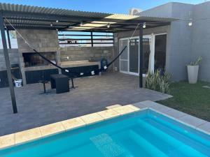a pergola over a swimming pool in a backyard at El quincho in Villa María