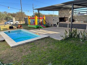 a backyard with a pool and a playground at El quincho in Villa María