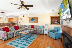 a living room with a couch and a tv at 7080 - Cool Breeze in Nags Head +92 photos